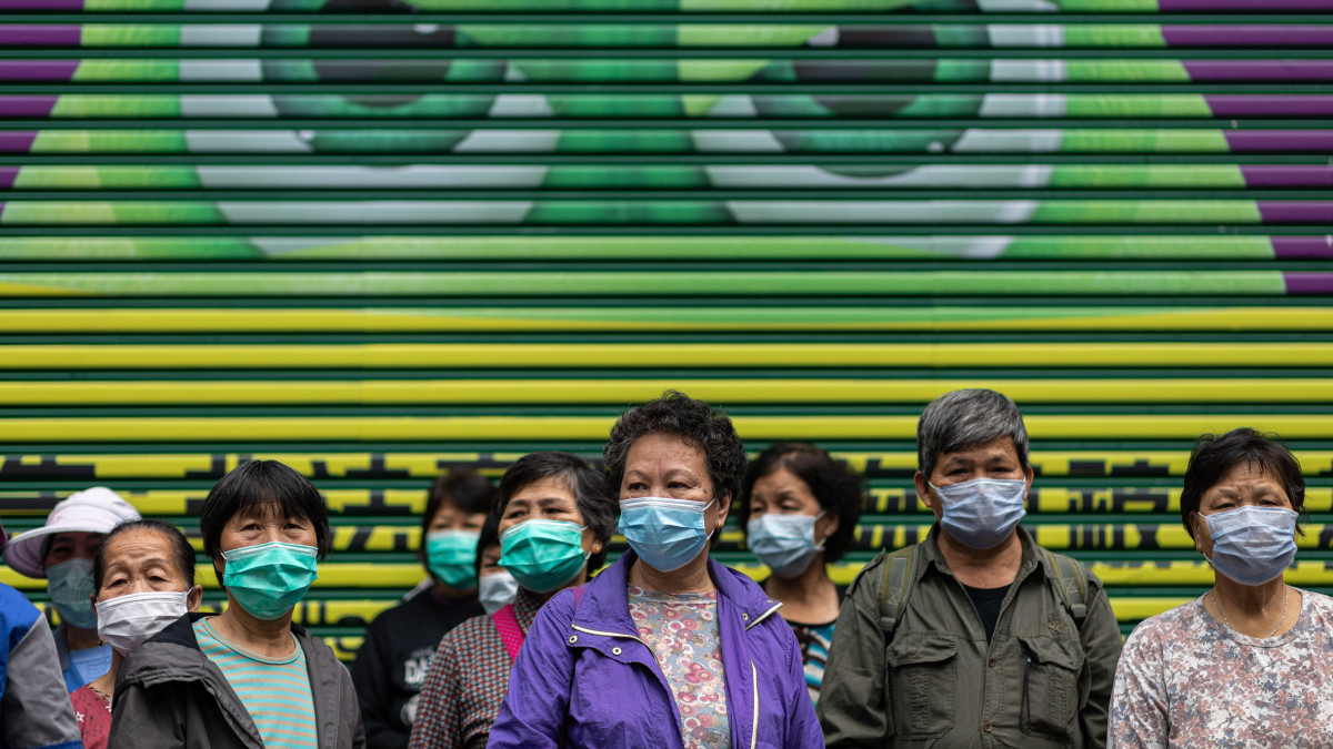 Ingyenes védőmaszkok osztására várnak hogkongi utcaseprők 2020. február 14-én. A tüdőgyulladást okozó vírus előidézte betegség halálos áldozatainak száma 1380-ra emelkedett Kínában, a legtöbben a járvány gócpontjában, Hupej tartomány székhelyén, Vuhanban hunytak el.