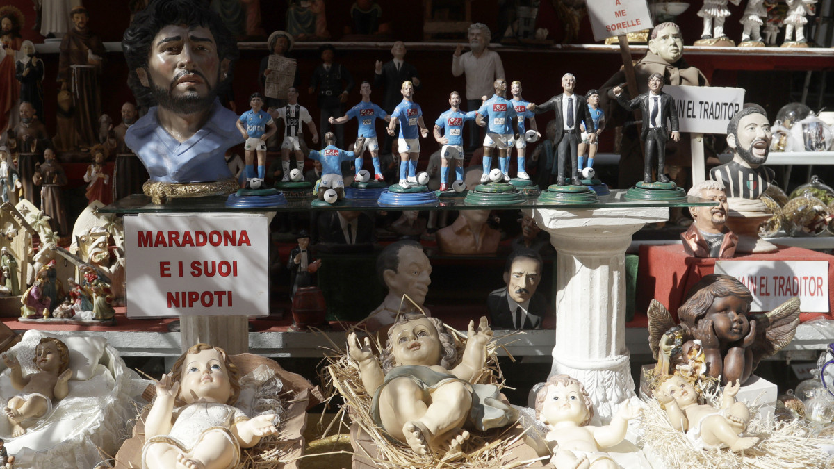 A 2020. február 20-án közreadott képen egy nápolyi üzlet standján elhelyezett feliraton az áll: Maradona és az unokaöccse. A felirat mögött Diego Maradona argentin labdarúgót, betlehemi jeleneteket, a Kisjézust, Máriát és Józsefet, valamint Dries Mertens jelenlegi Napoli játékost ábrázoló szobrocskákat helyezett el a tulajdonos 2019. szeptember 18-án. Az olasz Napoli futballcsapat Maradonának köszönhet számos kupagyőzelmet, valamint a gólkirályi címet. Maradona 1984-től 1991-ig játszott a nápolyi csapatban, de a mai napig istenként tisztelik.