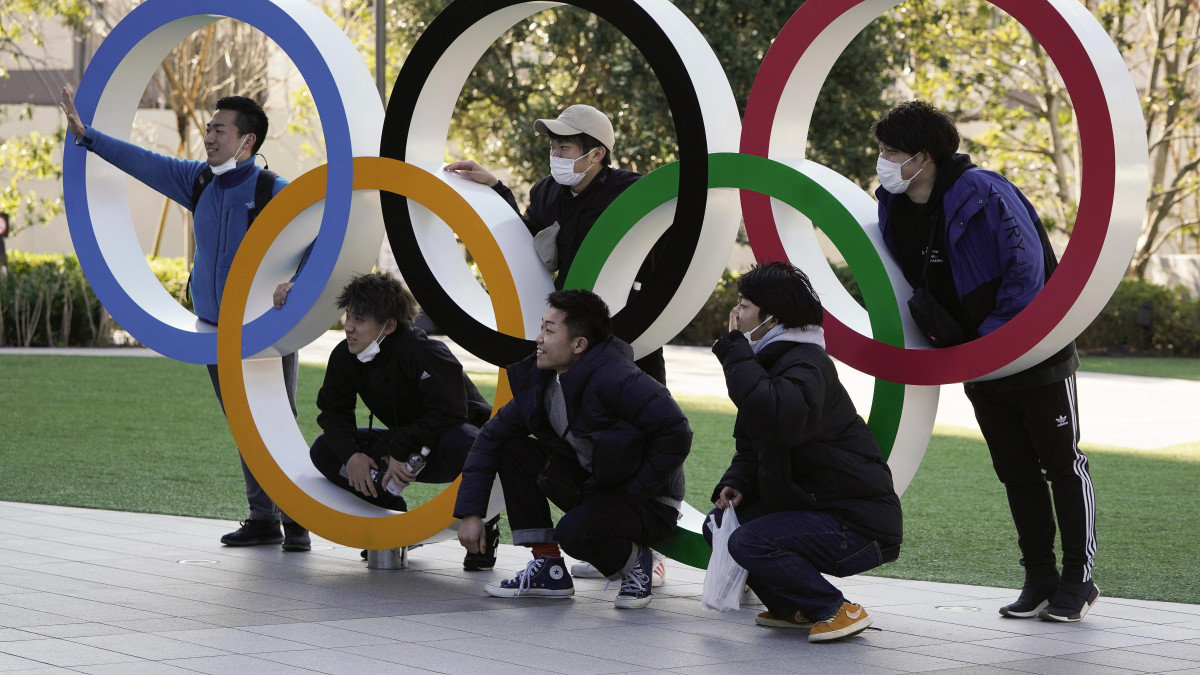 Védőmaszkot viselő látogatók az olimpiai ötkarikánál a 2020-as tokiói olimpia központi létesítménye, az új Nemzeti Stadion előtt 2020. február 27-én. Szuga Josihide, a japán kormány szóvivője előző nap megerősítette, hogy a Nemzetközi Olimpiai Bizottság folytatja az olimpia előkészítését az előzetes menetrend alapján. Japánban eddig hat ember vesztette életét a járványban, a fertőzöttek száma meghaladja a 890-et.