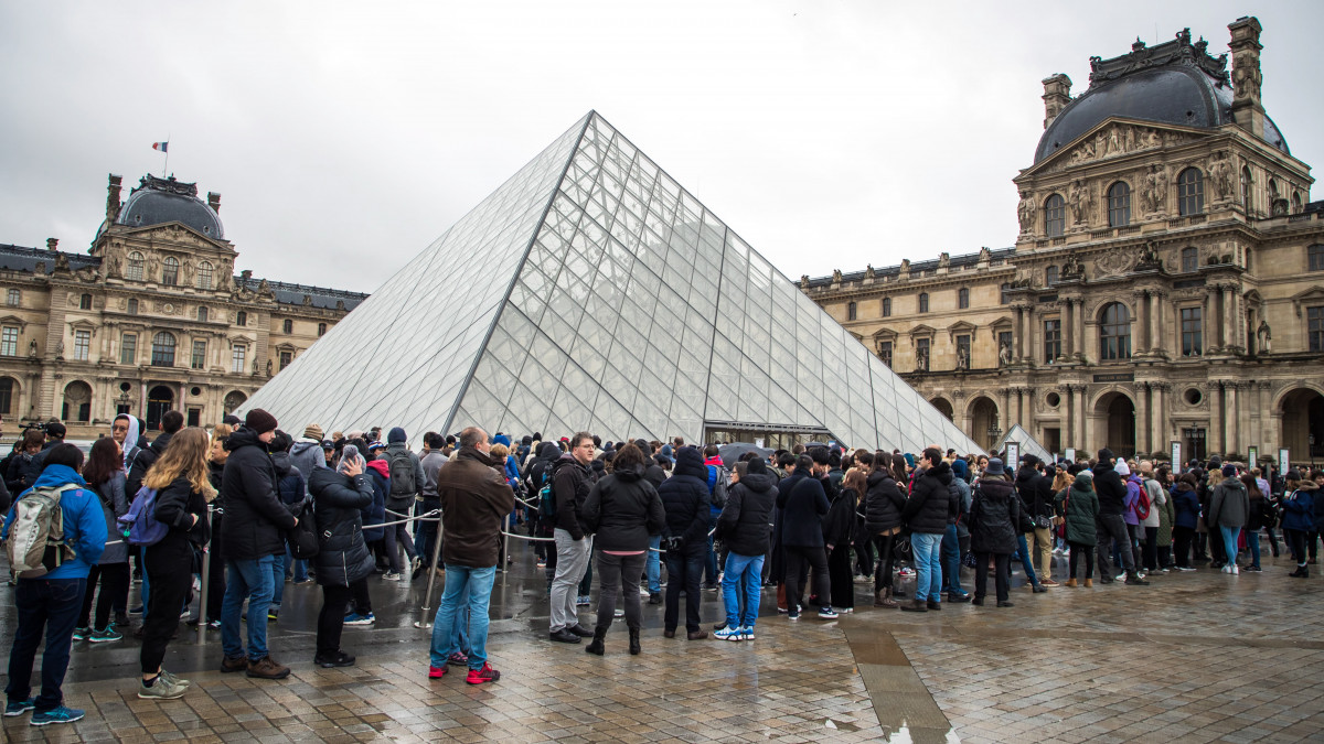 Látogatók várakoznak a párizsi Louvre múzeum bejárata előtt arra várva, hogy véget érjen a koronavírus-fertőzéstől tartó alkalmazottak tanácskozása 2020. március 2-án. Előző nap egész nap zárva maradt a világ leglátogatottabb múzeuma, mert az állománygyűlésen résztvevők úgy döntöttek, hogy élnek törvény adta jogukkal, miszerint megtagadhatják a munkát, ha a munkavégzés közvetlen veszélyt jelent az életükre vagy az egészségükre.