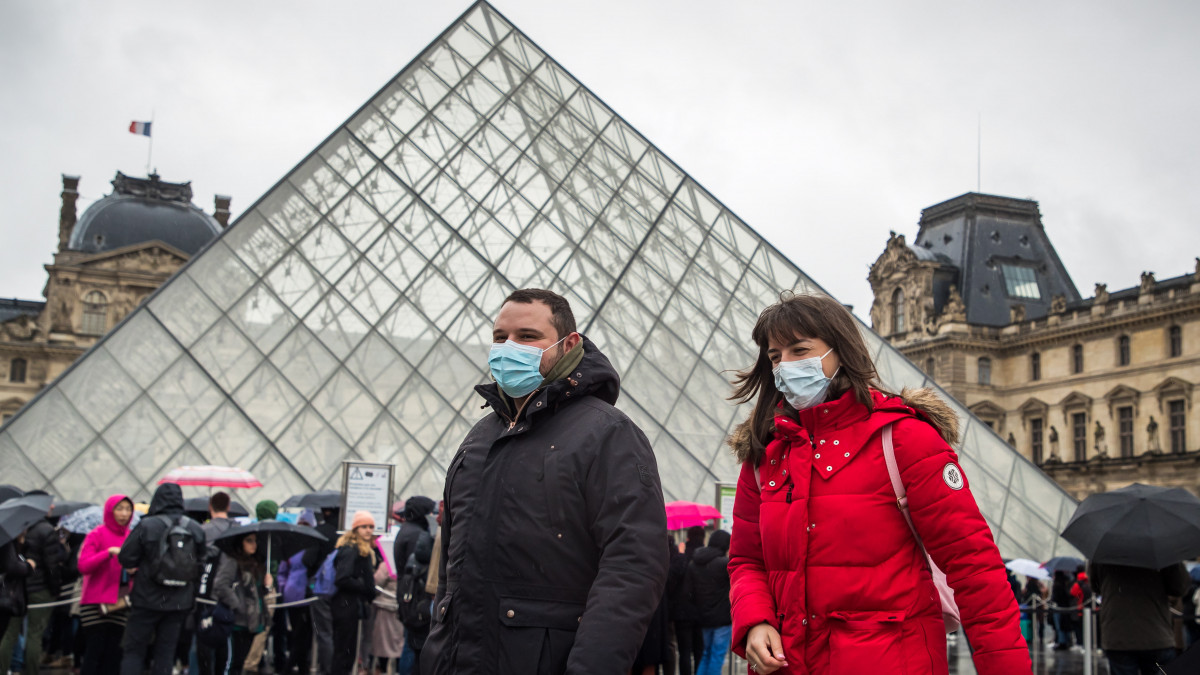 Szájmaszkot viselő látogatók várakoznak a párizsi Louvre múzeum bejárata előtt arra várva, hogy véget érjen a koronavírus-fertőzéstől tartó alkalmazottak tanácskozása 2020. március 2-án. Előző nap egész nap zárva maradt a világ leglátogatottabb múzeuma, mert az állománygyűlésen résztvevők úgy döntöttek, hogy élnek törvény adta jogukkal, miszerint megtagadhatják a munkát, ha a munkavégzés közvetlen veszélyt jelent az életükre vagy az egészségükre.