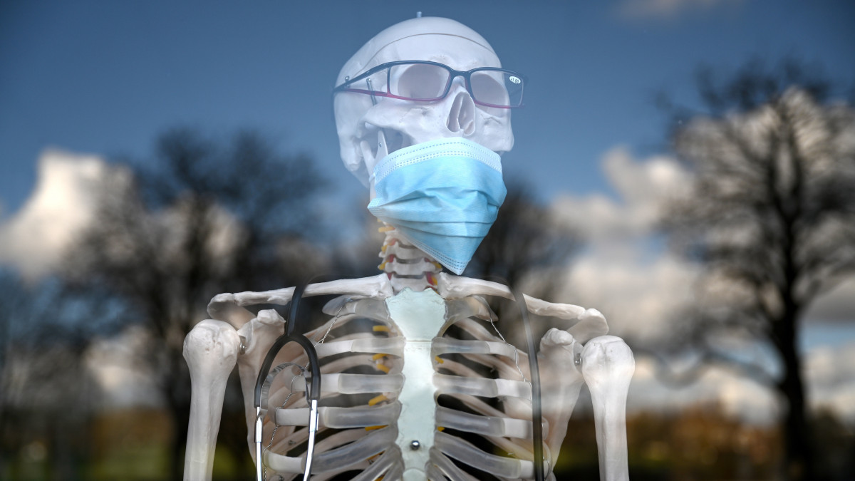 Arcmaszkot viselő anatómiai csontváz egy londoni gyógyászati segédeszköz-szaküzletben 2020. március 2-án. Boris Johnson brit miniszterelnök rendkívüli ülést hívott össze a koronavírus-járvány elleni intézkedések elrendelése céljából.