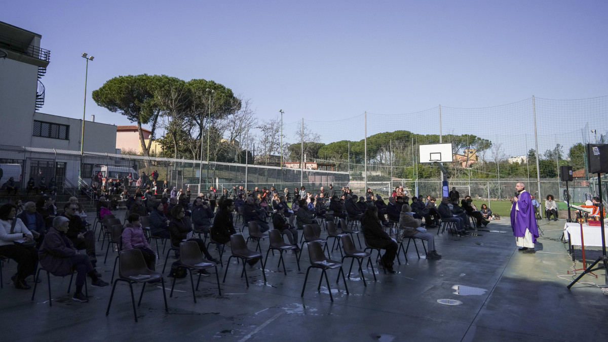 A plébánia sportpályáján tartja a vasárnapi misét Alessandro Pagliari atya (j) Rómában 2020. március 8-án. A tüdőgyulladást okozó újkoronavírus-járvány további terjedésének megállítására az olasz kormány vesztegzár alá vonta az észak-olaszországi Lombardia tartományt és az országrész 15 másik városát. A vírus eddig 233 ember halálát okozta Olaszországban.