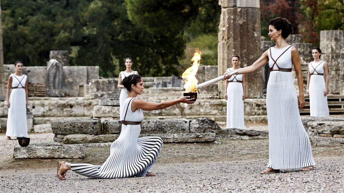 A főpapnő szerepét játszó Katerina Lehu az olimpiai láng fellobbantási ünnepségén Héra templománál, az eredeti olimpiai játékok helyszínén, az ókori Olümpiában 2017. október 24-én. A lángot a 2018-as Phjongcshangi téli olimpiára gyújtották meg.