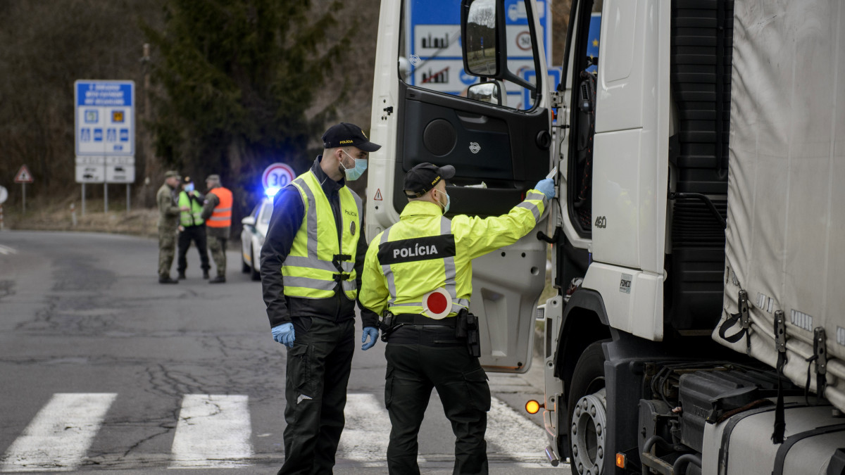 Szlovák rendőrök egy teherautót ellenőriznek a Somoskőújfalui és Sátorosbánya közötti határátkelőhelyen 2020. március 13-án. A koronavírus terjedésének megakadályozása érdekében a szlovák kormány reggel 7 órától a közúti határátkelőin - a lengyel határszakaszt kivéve - visszaállítja a határellenőrzést. Csak azokat engedik be Szlovákiába, akik szlovák állampolgárok, és akiknek az országban tartózkodási engedélyük van. Minden külföldről érkezőnek 14 napos karanténba kell vonulnia.