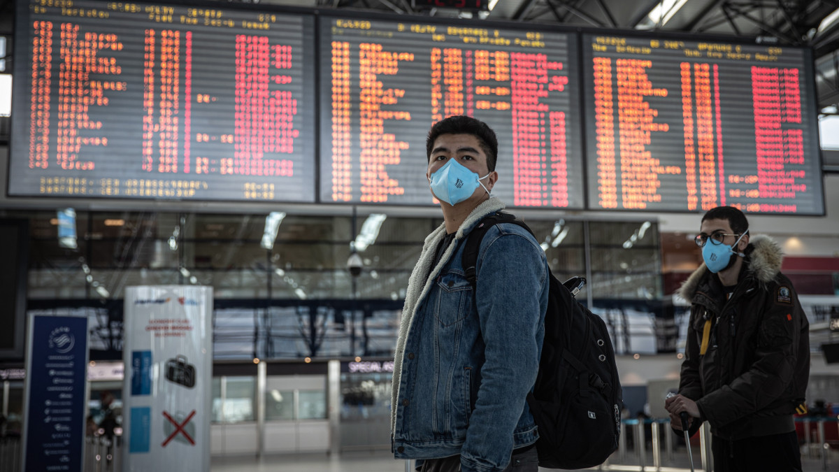 Védőmaszkot viselő férfi áll a prágai Vaclav Havel repülőtér járatinformációs kijelzőtáblái előtt 2020. március 13-án. Andrej Babis cseh miniszterelnök bejelentette, hogy a koronavírus terjedése miatt külföldi állampolgárok március 15-én éjféltől nem léphetnek be Csehországba, a cseh állampolgárok pedig nem utazhatnak külföldre. Kivételt ez alól csak azok az idegen állampolgárok képeznek, akiknek tartós lakhelyük van Csehországban, vagy 90 napnál hosszabb tartózkodásra feljogosító vízummal rendelkeznek.