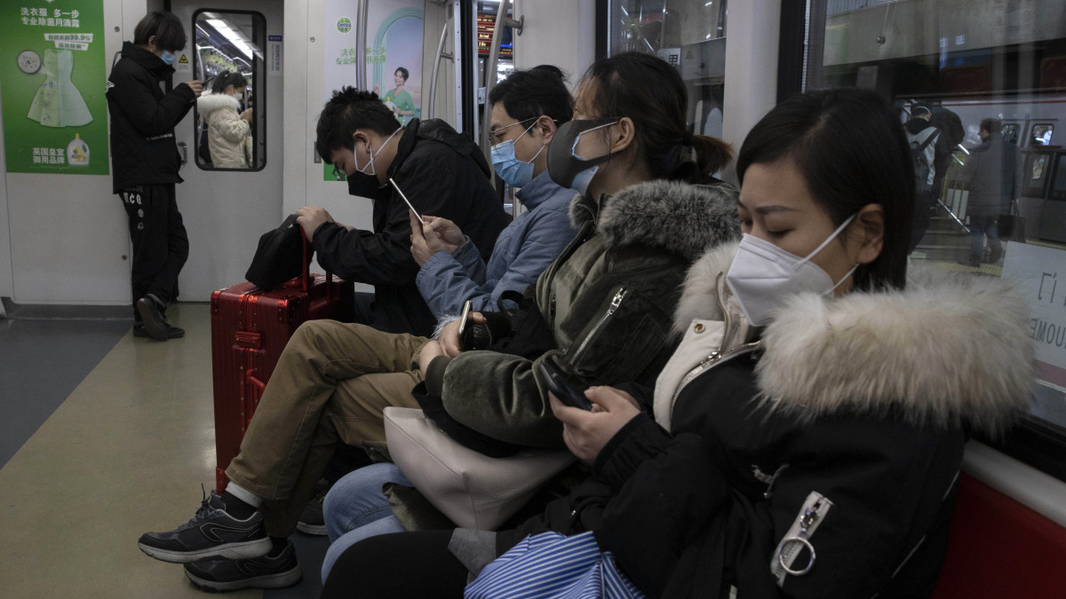 Utasok egy pekingi metrókocsiban a reggeli csúcsforgalom idején, 2020. március 9-én. Mivel alig jelentenek tüdőgyulladást okozó koronavírussal fertőzött új betegeket a kínai fővárosban, a dolgozók védőmaszkkal az arcukon és fertőtlenítővel a kezükben lassanként kezdenek visszatérni munkahelyükre. A hatóságok azonban továbbra is óvatosak, szeretnék ugyan újraindítani a gazdaságot, azonban tartanak a járvány újbóli felerősödésétől is.