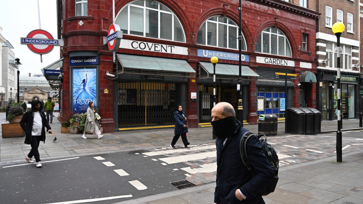 Száját és orrát sállal eltakaró férfi halad el a lezárt Covent Garden metróállomás előtt Londonban 2020. március 19-én. Nagy-Britanniában eddig 2644 koronavírussal fertőzött személyt regisztráltak és 72 ember vesztette életét.