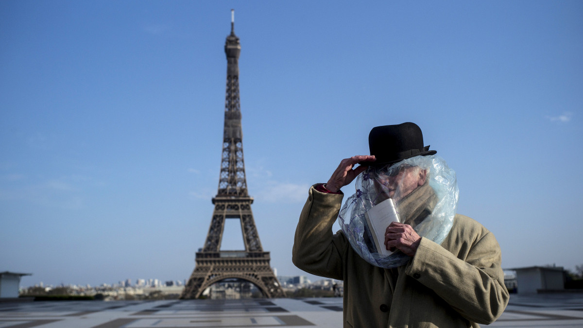 Nejlonzsákot a fejére húzva védekezik a koronavírus ellen egy férfi a párizsi Eiffel-torony előtt 2020. március 22-én. A francia parlament elfogadta azt a törvényjavaslatot, amely alapján lehetővé válik a két hónapos egészségügyi rendkívüli állapot kihirdetése a koronavírus-járvány idejére.