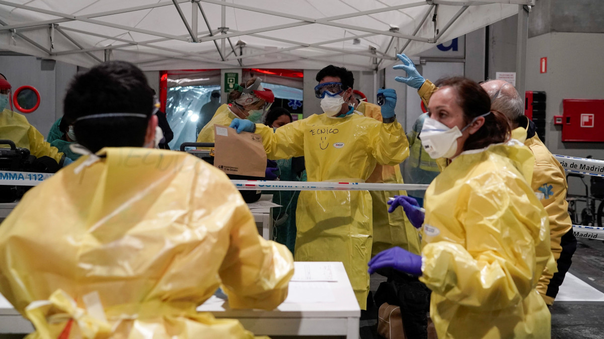 A koronavírus-járvány terjedése miatt védőruhát viselő egészségügyi alkalmazottak dolgoznak a madridi Ifema kongresszusi központban kialakított ideiglenes sürgősségi kórházban 2020. március 22-én. Pedro Sánchez kormányfő bejelentette az eredetileg jövő hétvégéig tartó szükségállapot meghosszabbítását újabb két héttel. Spanyolországban több mint 3500 újabb koronavírus-fertőzést igazoltak az elmúlt huszonnégy órában, ezzel az eddig kiszűrt betegek száma meghaladta a 28500 főt.