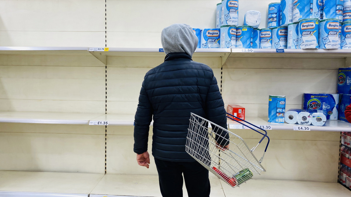 Üres polcok előtt áll egy vásárló egy londoni szupermarketben 2020. március 15-én. A koronavírus-járvány terjedése miatt Nagy-Britanniában az emberek elkezdték felvásárolni az élelmiszereket.