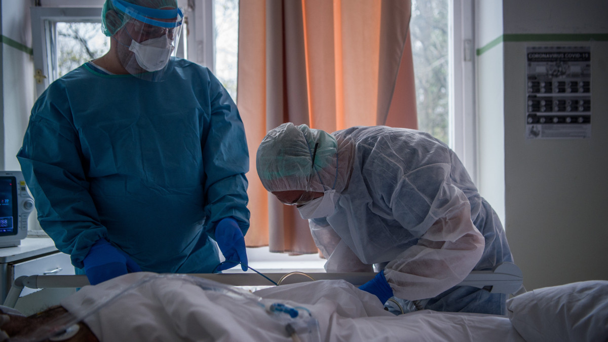 Orvos és ápoló egy koronavírussal fertőzött beteget lát el Országos Korányi Pulmonológiai Intézetben kialakított izolációs teremben 2020. március 25-én.