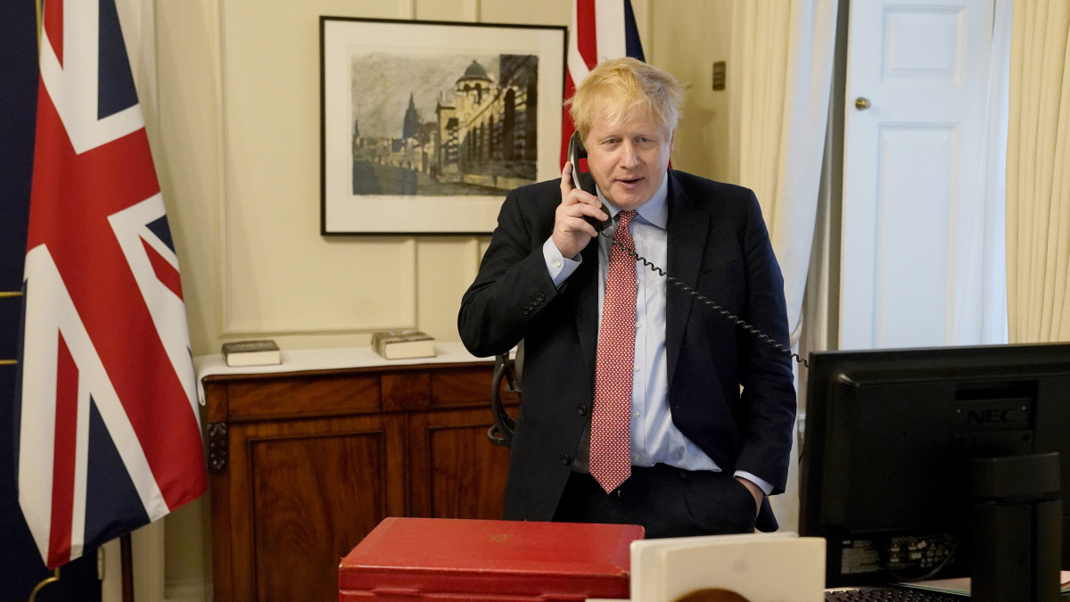 A brit kormányfői rezidencia, a Downing Street 10. által közreadott képen Boris Johnson brit miniszterelnök telefonon beszél II. Erzsébet brit királynővel, aki a koronavírus-járvány miatt a windsori kastélyban tartózkodik 2020. március 26-án. Nagy-Britanniában a lakosság három napja csak az alapvető szükségleti cikkek, főleg élelmiszerek és gyógyszerek beszerzésekor léphet az utcára az új koronavírus-járvány megfékezése érdekében.