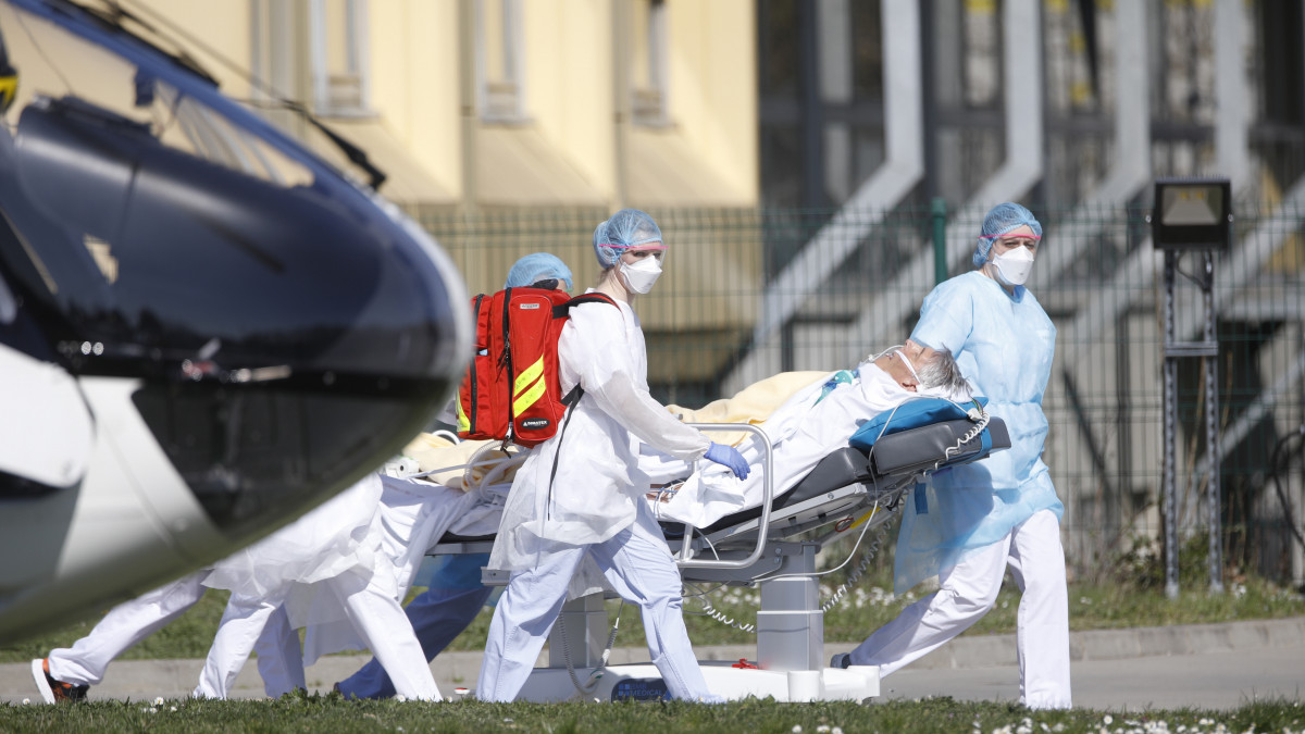 A koronavírussal fertőzött betegek egyikét szállítják el ápolók a kelet-franciaországi Mulhouse város kórházából 2020. március 23-án. A francia parlament az előző nap elfogadta azt a törvényjavaslatot, amely alapján lehetővé válik a két hónapos egészségügyi rendkívüli állapot kihirdetése a koronavírus-járvány idejére.
