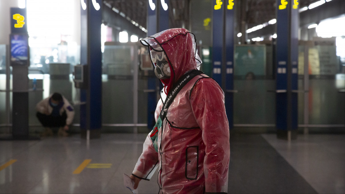 Védőöltözéket viselő utas a szinte teljesen elnéptelenedett pekingi repülőtéren 2020. március 28-án. A kínai külügyminisztérium a koronavírus esetleges továbbterjedése miatt a mai naptól megtiltotta a külföldi állampolgárok beutazását az országba.