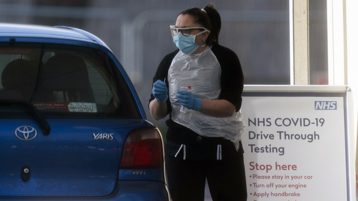 Koronavírustesztet végeznek az autósokon egy londoni élménypark előtt létesített állomáson 2020. március 29-én. Nagy-Britanniában a koronavírus-járvány miatt a lakosság csak az alapvető szükségleti cikkek és gyógyszerek beszerzése, valamint napi egy szabadtéri testmozgás céljából léphet ki az utcára, illetve akkor, ha orvosi segítségre van szüksége. Az országban 19 ezer fölé nőtt a koronavírussal igazoltan fertőzöttek száma, a járványban eddig 10235-en vesztették életüket.