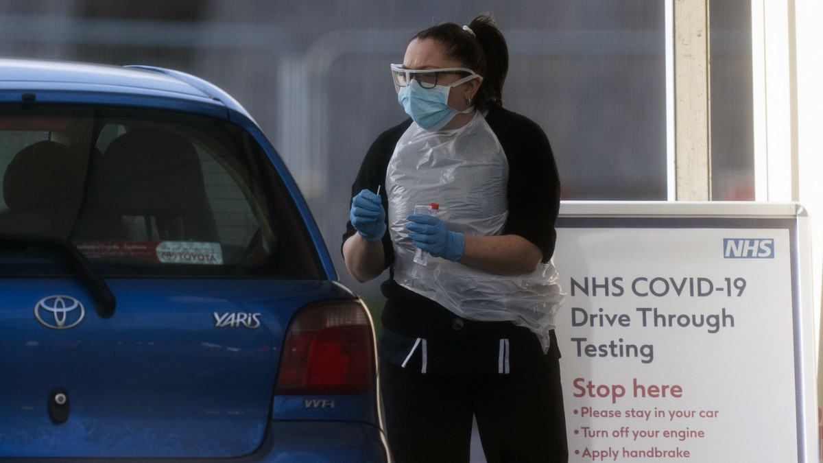 Koronavírustesztet végeznek az autósokon egy londoni élménypark előtt létesített állomáson 2020. március 29-én. Nagy-Britanniában a koronavírus-járvány miatt a lakosság csak az alapvető szükségleti cikkek és gyógyszerek beszerzése, valamint napi egy szabadtéri testmozgás céljából léphet ki az utcára, illetve akkor, ha orvosi segítségre van szüksége. Az országban 19 ezer fölé nőtt a koronavírussal igazoltan fertőzöttek száma, a járványban eddig 10235-en vesztették életüket.
