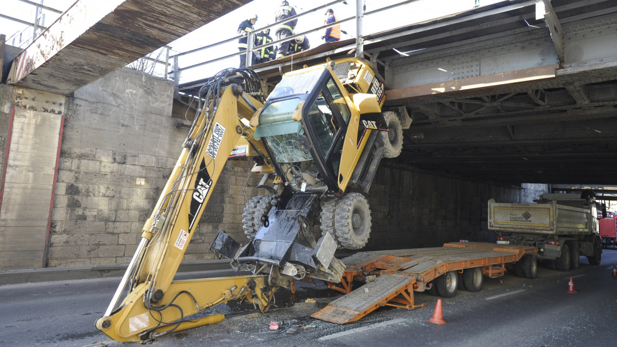 A kőbányai vasúti felüljáró alá szorult, munkagépet szállító teherautó műszaki mentésén dolgoznak a tűzoltók 2020. április 1-jén. A baleset a Könyves Kálmán körúton, az Árpád híd felé vezető oldalon történt.