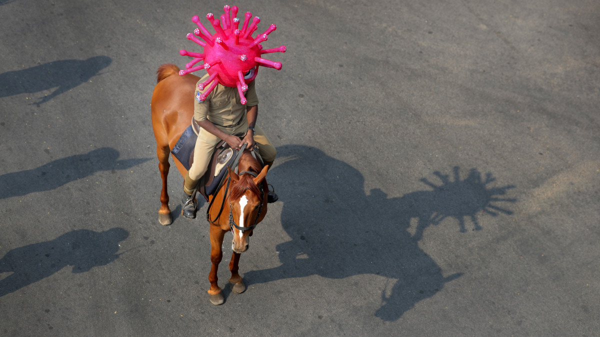 Indiai lovas rendőr  koronavírust formázó sisakban hívja fel az emberek figyelmét a vírus terjedésének veszélyére az indiai Hiderábádban 2020. április 2-án.