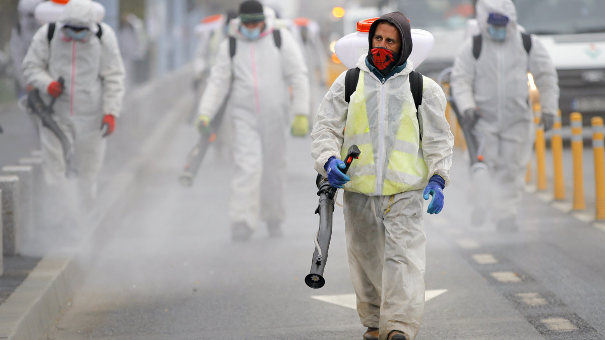 A koronavírus-járvány megfékezésének érdekében egy bukaresti utcát fertőtlenítenek védőruhás városi alkalmazottak 2020. március 31-én. MTI/AP/Vadim Ghirda