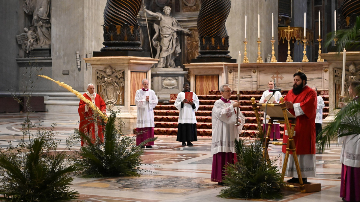 Ferenc pápa (b) pálmaággal a vatikáni Szent Péter-bazilikában zárt kapuk mögött pontifikált virágvasárnapi miséjén a koronavírus-járvány miatt bevezetett kijárási korlátozások idején, 2020. április 5-én.