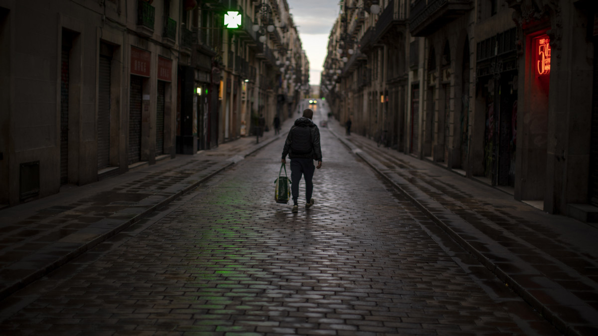 Magányos gyalogos egy barcelonai utcán 2020. március 26-án. Spanyolországban, ahol újabb két héttel meghosszabbították a koronavírus-járvány elleni védekezésül bevezetett szükségállapotot, 56 ezer fölé emelkedett a fertőzöttek száma, és 4089-en vesztették életüket