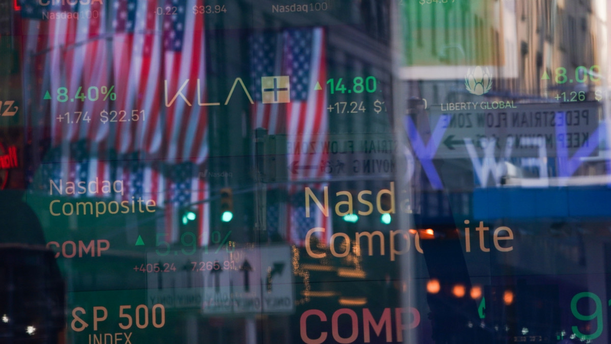 Az Amerikai Egyesült Államok zászlaja tükröződik a Nasdaq értéktőzsde ablakán a New York-i Times Square-en 2020. március 24-én. Jelentős emelkedéssel nyitottak a New York-i tőzsde irányadó indexei, a kockázatvállalási hangulat sokat javult azokra a jelekre, hogy közel a megállapodás az amerikai kormányzat kétezer milliárd dolláros gazdasági mentőcsomagjáról.