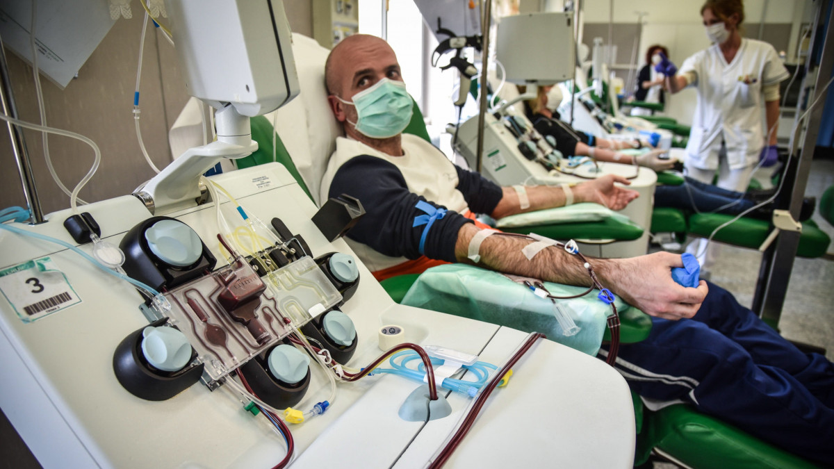 A koronavírusból kigyógyult páciens egyikétől vesznek plazmamintát a paviai San Matteo kórházban 2020. április 6-án. Olaszországban 128 948 regisztrált koronavírus-fertőzött van és 15 887 ember vesztette életét.