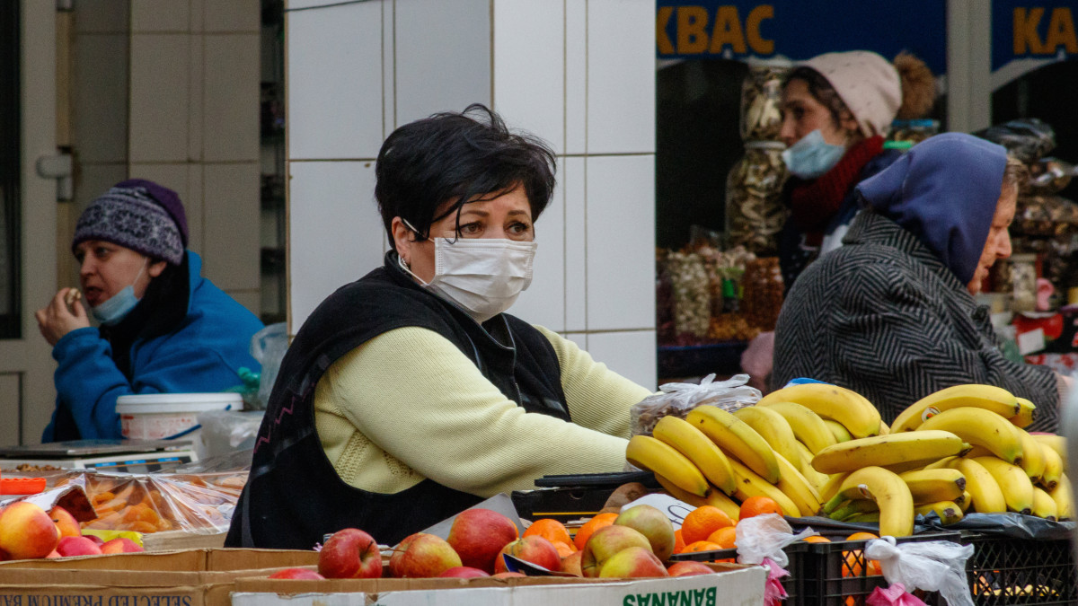A koronavírus-járvány miatt védőmaszkot viselő gyümölcsárus Ungvár központi piacán 2020. március 18-án.