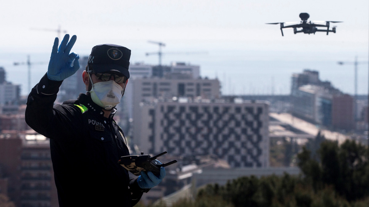 Drónnal ellenőrzi egy rendőr a kijárási korlátozás betartását Barcelonában 2020. április 8-án. A koronavírus járványa miatt 25 napja kijárási korlátozás van érvényben.