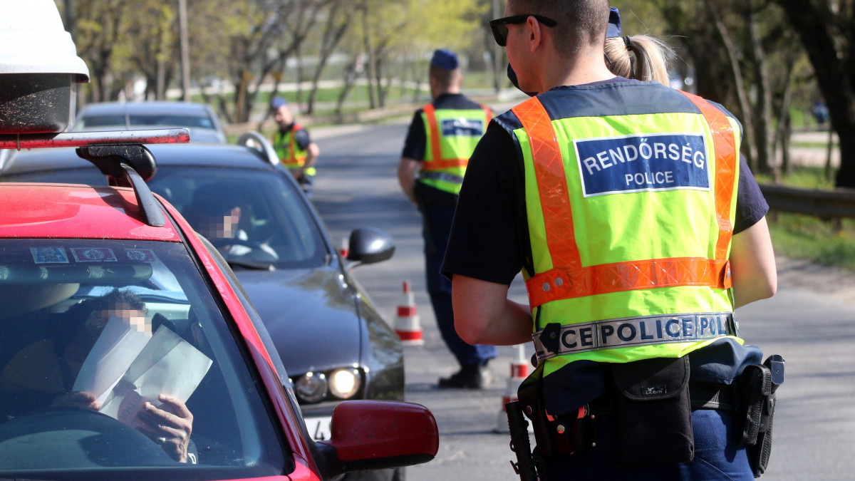 Rendőrök autósokat ellenőriznek Miskolcon, a Miskolctapolcára vezető úton 2020. április 12-én. A koronavírus-járvány miatt március 28-án kihirdetett kijárási korlátozást a kormány április 9-én határozatlan időre meghosszabbította.