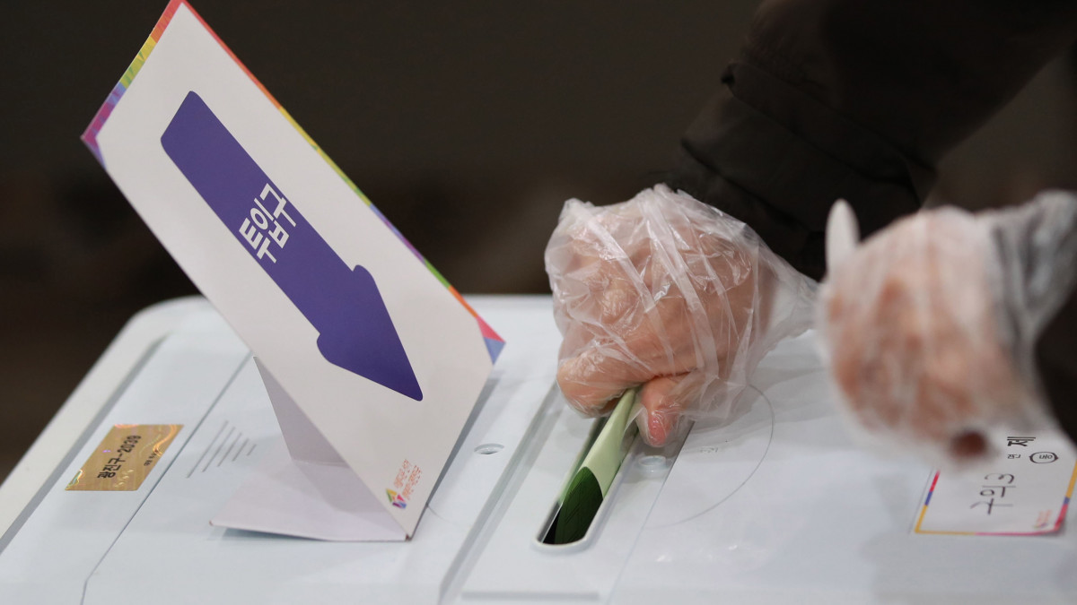 Védőkesztyűt viselő szavazó a dél-koreai parlamenti választásokon Szöulban a kronavírus-járvány idején, 2020. április 15-én.