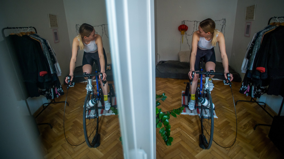 A koronavírus-járvány miatt önkéntes karanténban lévő kerékpáros edz görgővel budapesti otthonában 2020. március 26-án.