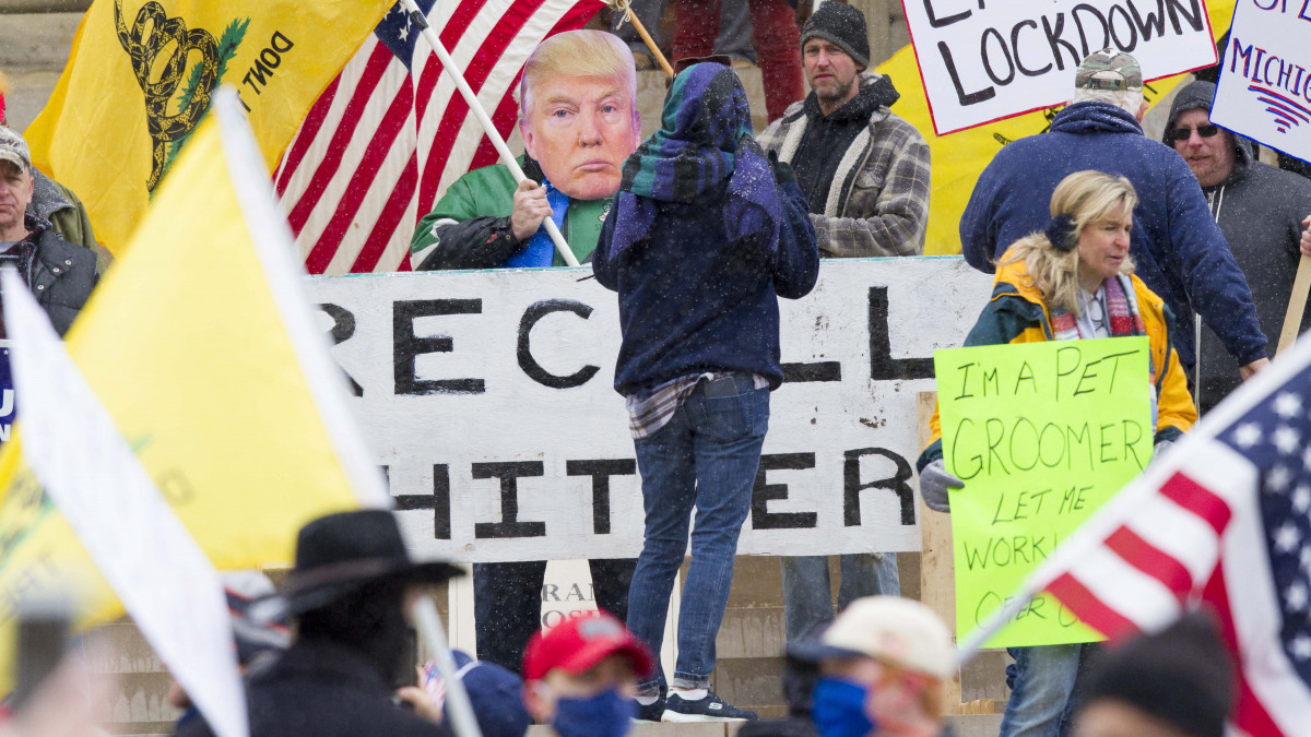 Gretchen Whitmer kormányzó ellen tüntetnek a koronavírus-járvány miatt bevezetett korlátozó intézkedésekkel elégedetlen emberek Michigan állam törvényhozásának épülete előtt Lansingban 2020. április 15-én.