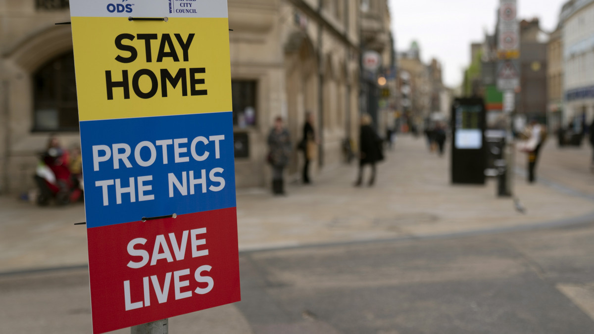 Maradj otthon, védd az Országos Egészségügyi Szolgálatot és ments életeket jelentésű feliratok az oxfordi Fő utcában 2020. április 17-én. A brit kormány egyelőre fenntartja a koronavírus-járvány miatt bevezetett kijárási korlátozásokat, amelyek szerint a lakosság csak a legszükségesebb esetekben hagyhatja el otthonát.