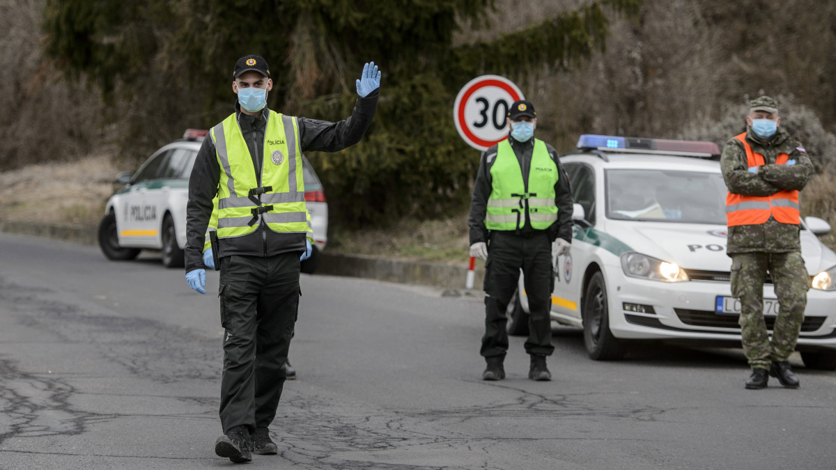 Szlovák rendőrök a Somoskőújfalui és Sátorosbánya közötti határátkelőhelyen 2020. március 13-án. A koronavírus terjedésének megakadályozása érdekében a szlovák kormány reggel 7 órától a közúti határátkelőin - a lengyel határszakaszt kivéve - visszaállítja a határellenőrzést. Csak azokat engedik be Szlovákiába, akik szlovák állampolgárok, és akiknek az országban tartózkodási engedélyük van. Minden külföldről érkezőnek 14 napos karanténba kell vonulnia.