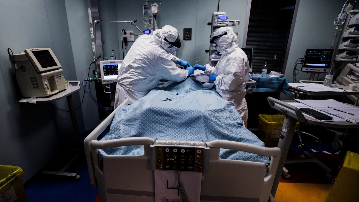 Védőöltözéket viselő orvosok és nővérek a római Casal Palocco negyed kórházának koronavírussal fertőzött betegeket ápoló intenzív osztályán 2020. április 22-én.