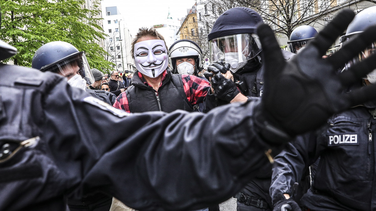 A koronavírus-járvány miatt elrendelt korlátozó intézkedések feloldását követelő tüntetők egyikét tartóztatják le rendőrök Berlinben 2020. április 25-én. A be nem jelentett tiltakozást a rendőrök később feloszlatták.