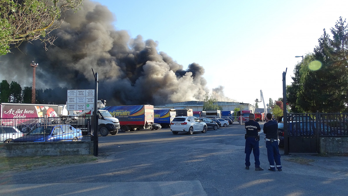 Egy szárazáru tárolására használt raktár tetőszerkezetében keletkezett tűz oltásán dolgoznak tűzoltók a Bács-Kiskun megyei Izsákon 2020. április 26-án.