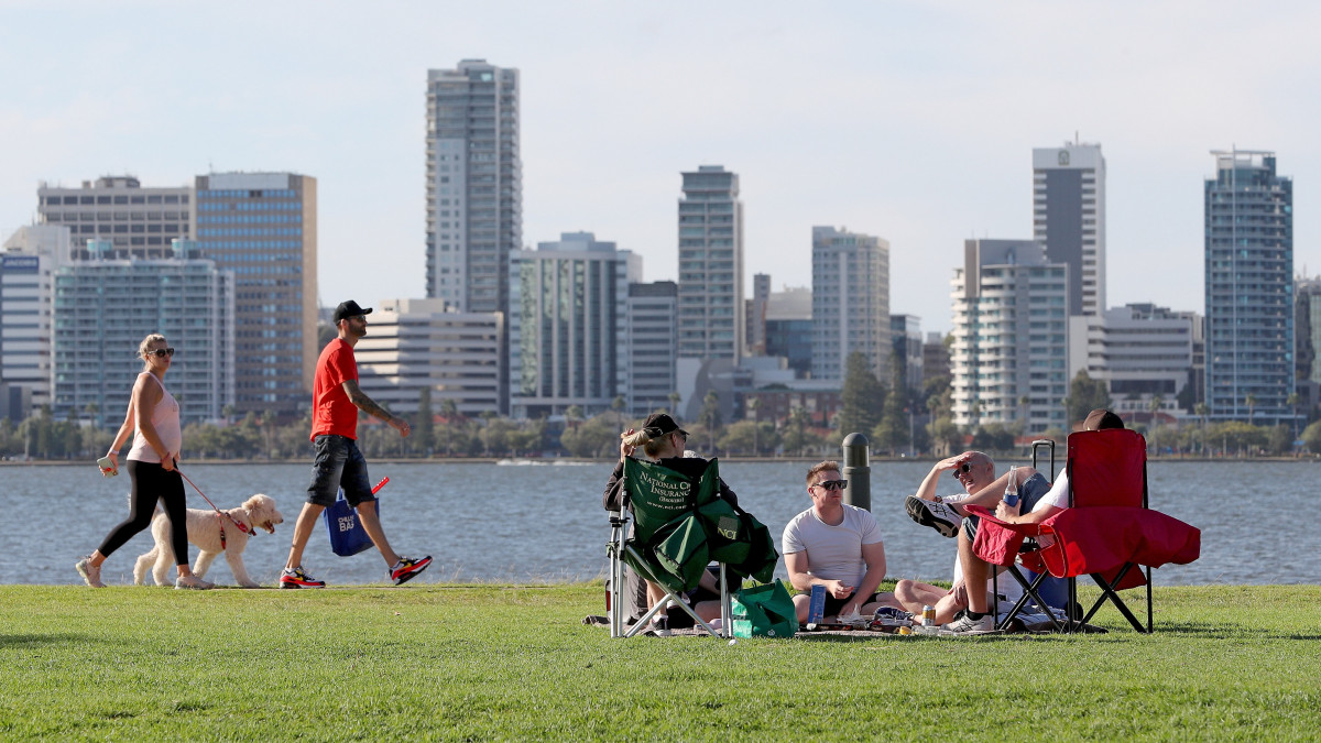 Sétáló és napozó emberek az ausztráliai Perth egyik parkjában 2020. április 27-én. Nyugat-Ausztráliában enyhítették a koronavírus-járvány miatt bevezetett kijárási korlátozásokat, már akár tíz ember is részt vehet egyszerre meghatározott szabadtéri tevékenységekben.
