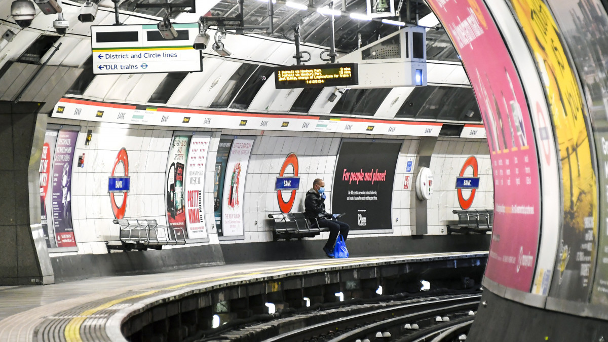Védőmaszkot viselő utas a londoni metró Bank nevű állomásán 2020. április 25-én. A legújabb statisztika szerint Nagy-Britanniában meghaladta a húszezret az új koronavírus okozta járvány halálos áldozatainak száma.