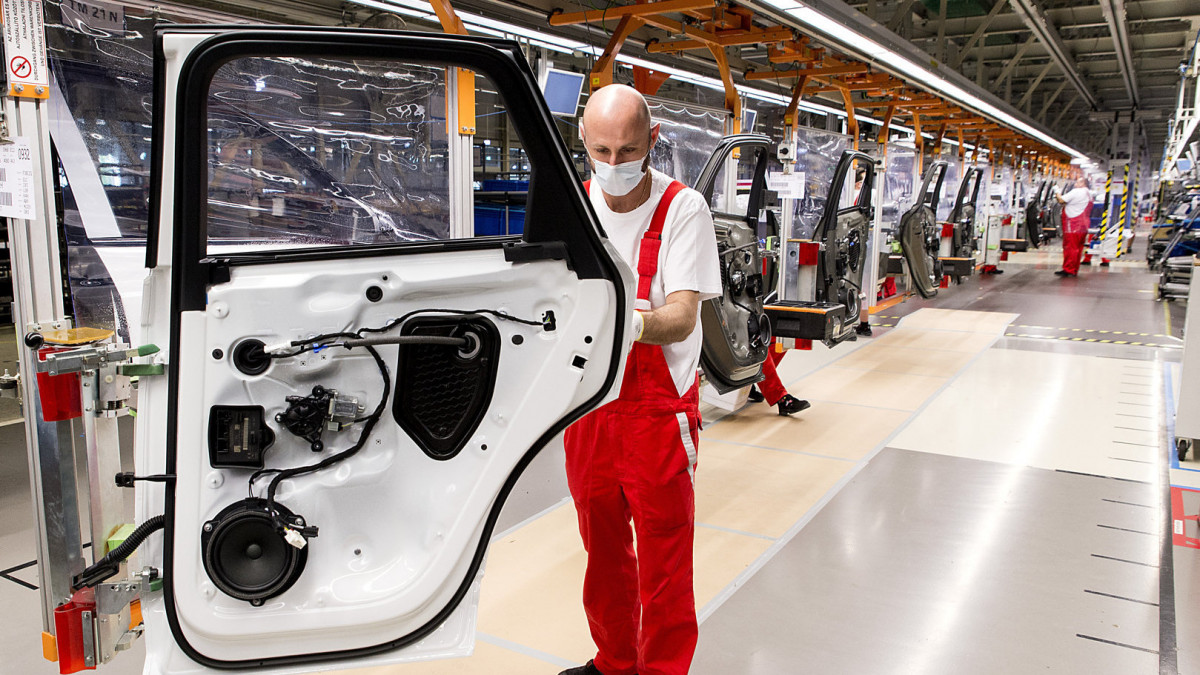 Dolgozó egy autó ajtaját szereli össze, mögötte a koronavírus elleni védekezés részeként elhelyezett fólialapok az összeszerelő soron az Audi Hungaria Motor Kft. győri gyárának járműszerelő részlegében 2020. április 27-én. Ezen a napon sikeresen újraindult az Audi Hungaria járműgyártása, mind a présüzemben, karosszériaüzemben, lakkozóban és a járműszereldében. Első lépésben egy műszakban kétezer járműgyári munkatárs kezdte meg munkáját. A járműszereldében műszakonként jelenleg 250 autót gyártanak, a vállalat a termelést a következő hetekben fokozatosan szeretné felfuttatni.
