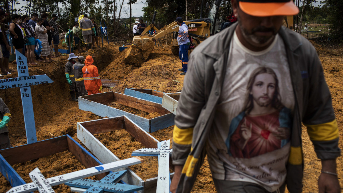 Sírásók dolgoznak a koronavírus-járványban elhunyt áldozatok számára kialakított tömegsíroknál a brazíliai Manaus egyik temetőjében 2020. április 28-án.