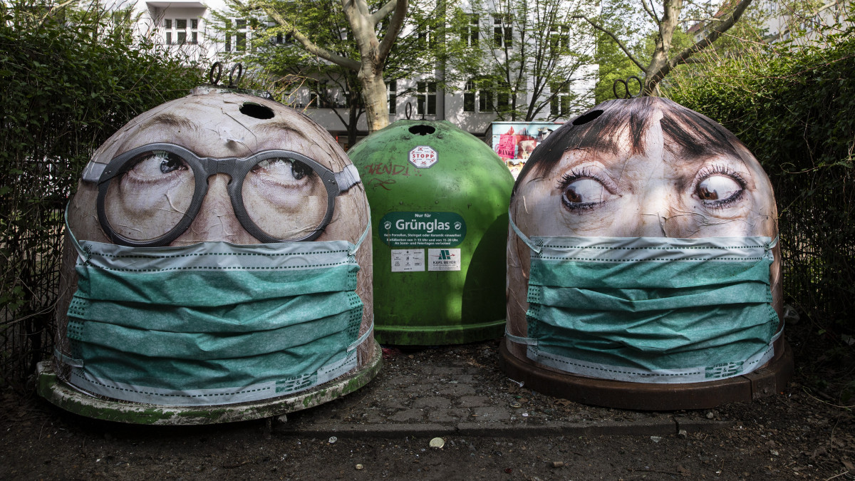 Védőmaszkos arcokat ábrázoló szelektív hulladékgyűjtő edények Berlinben a koronavírus-járvány idején, 2020. április 29-én