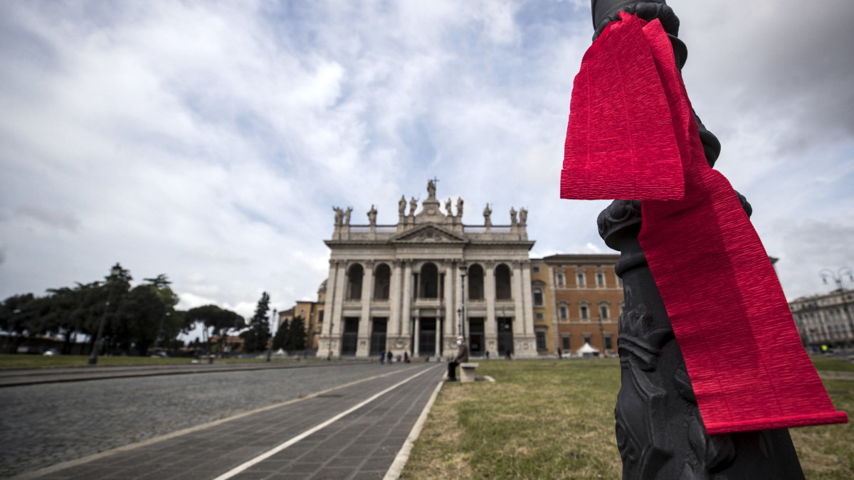 Vörös szalag a csaknem teljesen néptelen római San Giovanni tér egyik lámpaoszlopán 2020. május 1-jén, a koronavírus-járvány idején.