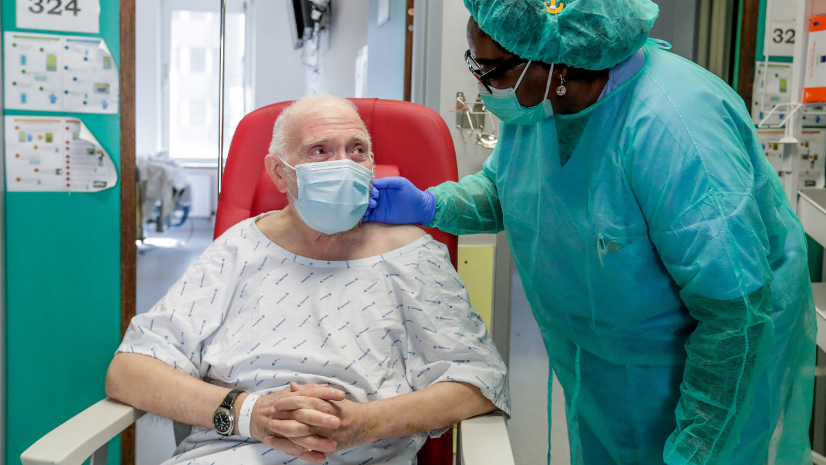 A koronavírus okozta betegségből meggyógyult és haza készülő 85 éves Andrét megsimogatja Alfonsine, egy nővér a brüsszeli Etterbeek-Ixelles Kórházban 2020. április 29-én.