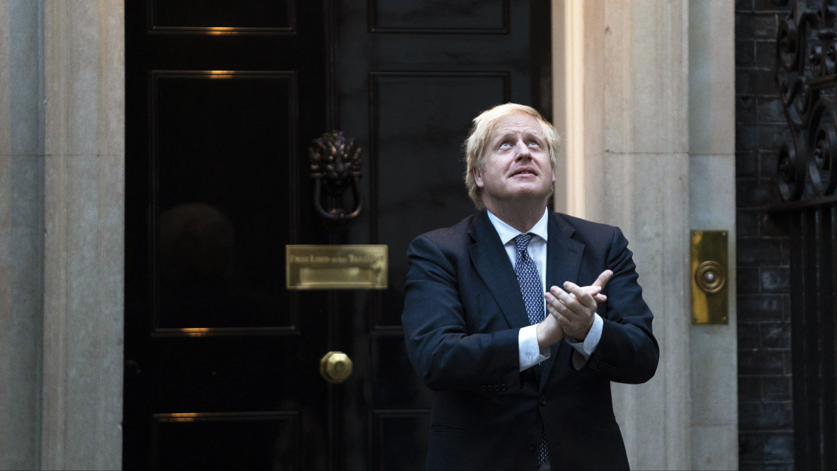 A koronavírus okozta betegségből felgyógyult Boris Johnson brit miniszterelnök a londoni kormányfői rezidencia, a Downing Street 10. kapujában 2020. április 30-án részt vesz a tapsoljunk a rólunk gondoskodóknak mottóval meghirdetett hetenkénti akcióban, amikor az emberek Nagy-Britannia-szerte tapssal köszönik meg mindazok tevékenységét, akik a koronavírus-járvány alatt a lakosság biztonságáért, egészségéért, ellátásáért, az ország működőképességének fenntartásáért dolgoznak.