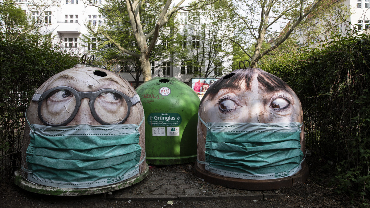 Védőmaszkos arcokat ábrázoló szelektív hulladékgyűjtő edények Berlinben a koronavírus-járvány idején, 2020. április 29-én