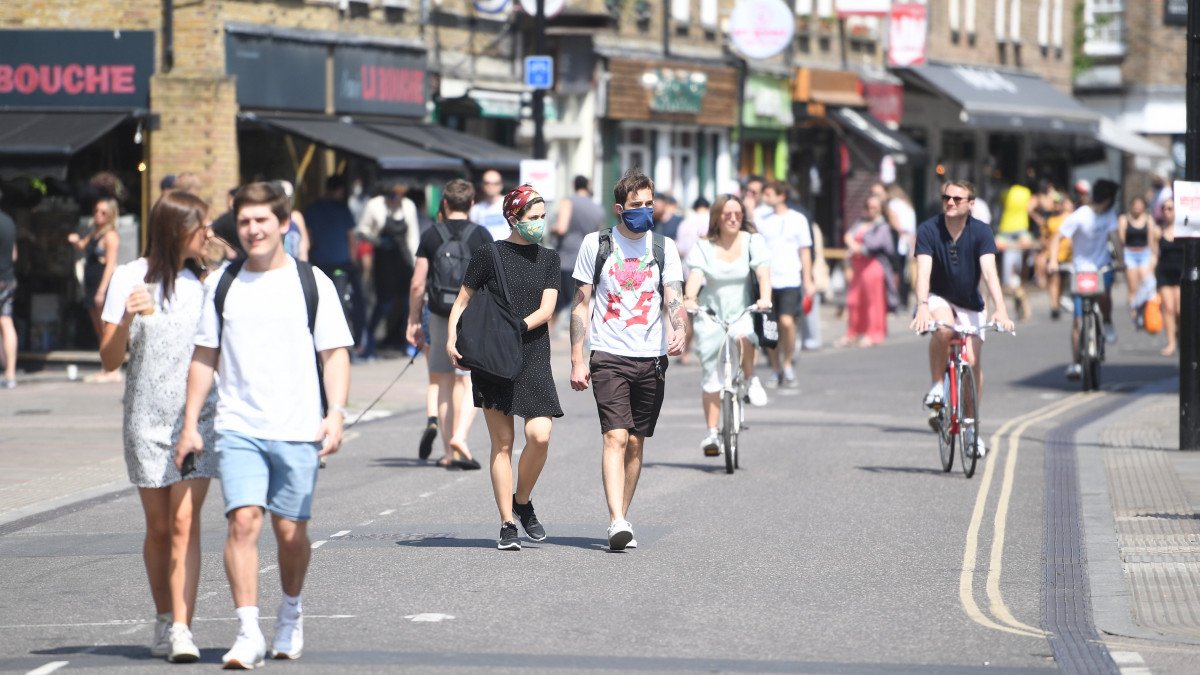 Sétáló emberek egy  kelet-londoni utcán a koronavírus-járvány idején 2020. május 9-én.