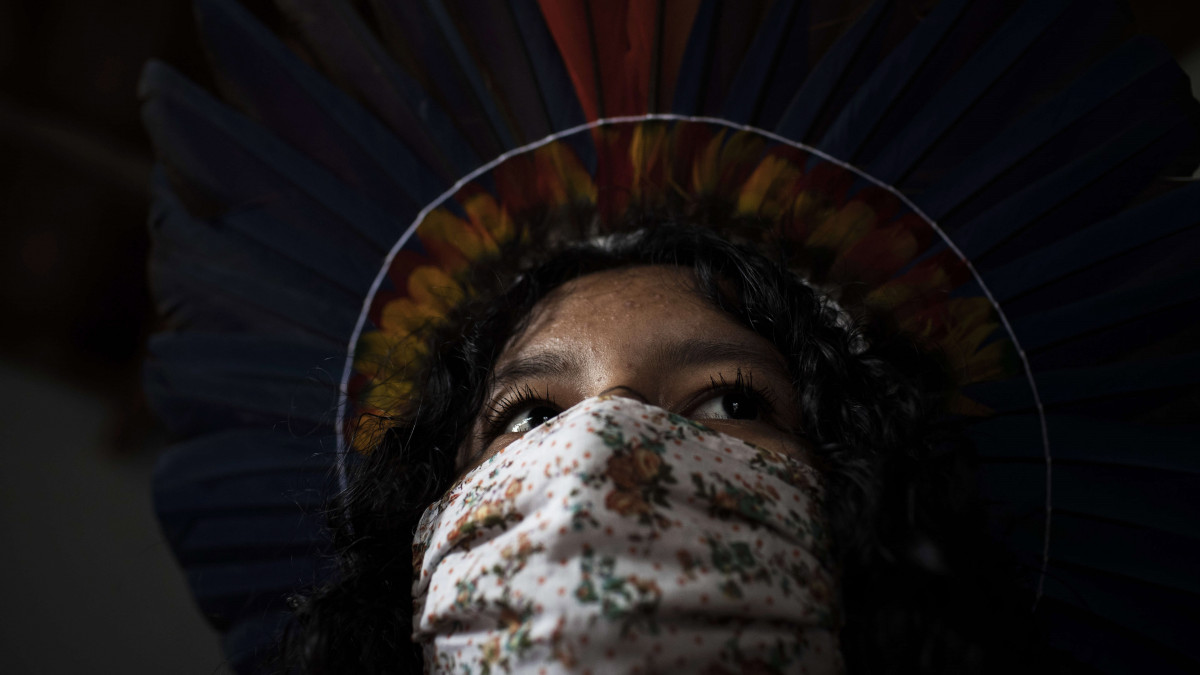 Szájmaszkot visel az őslakos Satere-Mawe indián törzshöz tartozó fiatal lányok egyike az Amazónia szövetségi állambeli  Manausban 2020. május 13-án. A bennszülött törzs tagjai saját kézműves termékeik értékesítéséből szerezték eddig jövedelmüket, de a koronavírus-járvány megjelenése óta egészségügyi védőmaszkok gyártására álltak át.